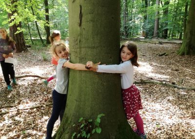 Kinder umarmen einen Baum