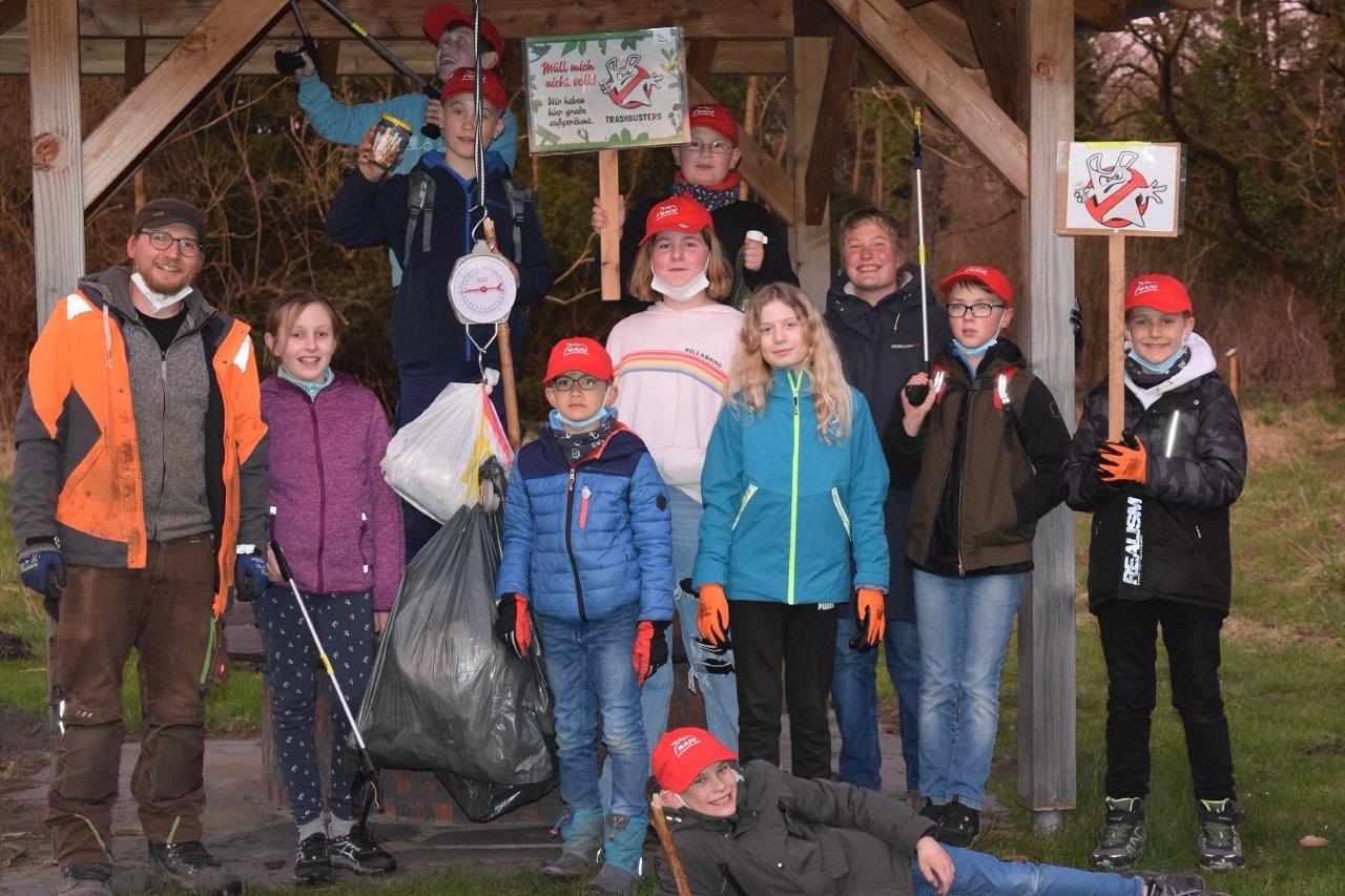 Gruppenfoto mit Kindern mit Schildern und gesammeltem Müll